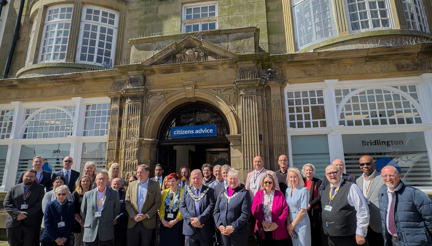 Photograph of staff, volunteers, partners and guests gathered outside the new office of Citizens Advice Hull & East Riding at 6 Manor Street, Bridlington