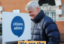 Photograph shows a man standing in front of a building with a Citizens Advice sign with text overlaid: #WeAreCitizensAdvice We are the people's champion